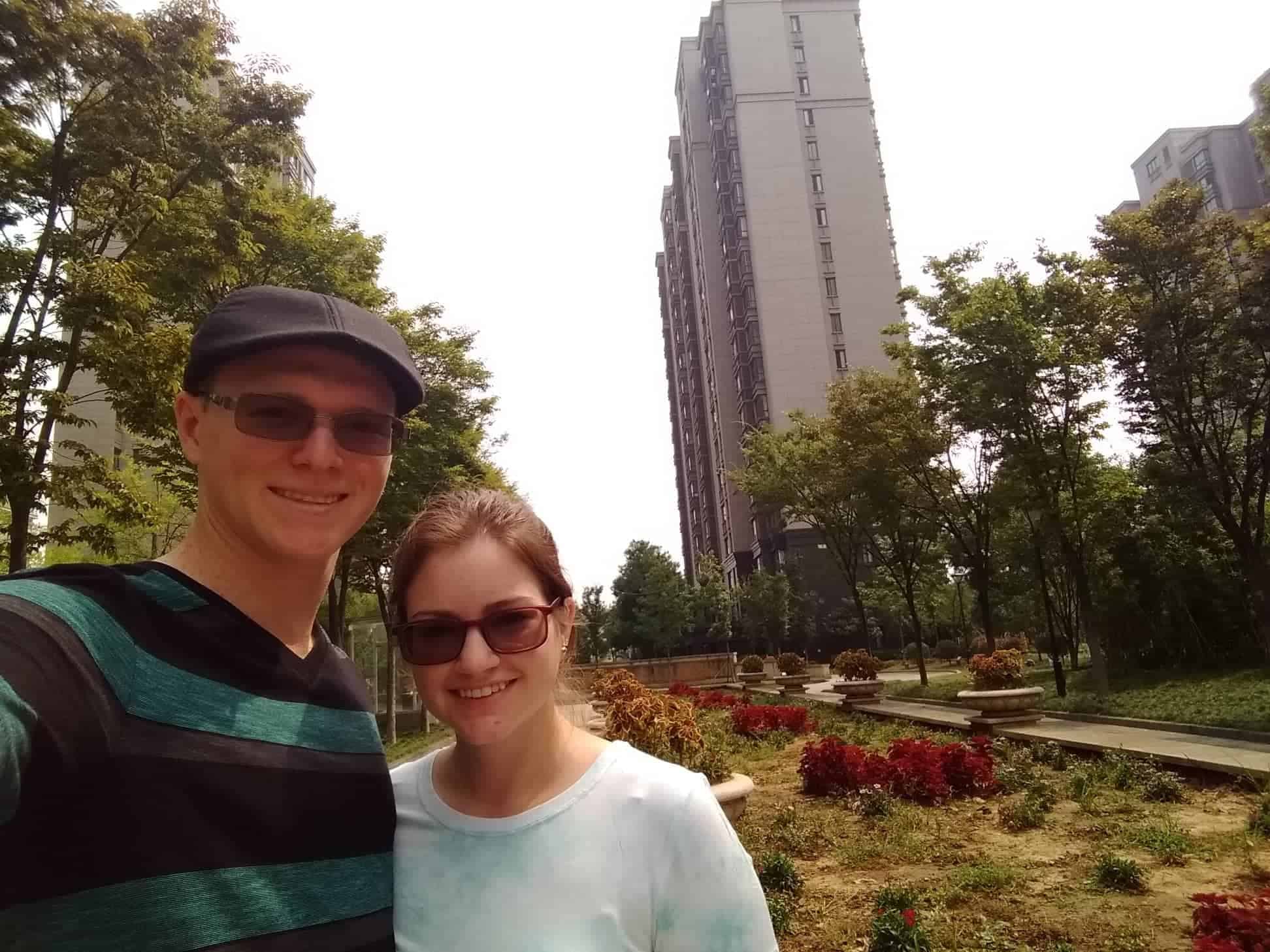 Derek and Kacie by a garden in their apartment complex in Nanjing, China